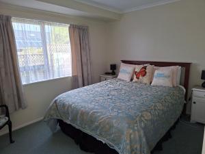a bedroom with a bed with pillows and a window at Digs Homestay in Stratford