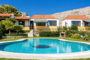 a swimming pool in front of a house at Villa Seashell in Pefki