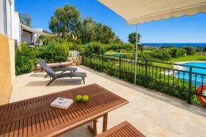 a patio with a bench and a table with apples on it at Villa Seashell in Pefki +14 photos
