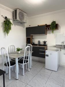 a kitchen with a table and chairs and a refrigerator at Estadia rápida - Quarto 2 in Bayeux +8 photos
