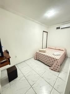 a white room with a bed and a mirror at Estadia rápida - Quarto 2 in Bayeux