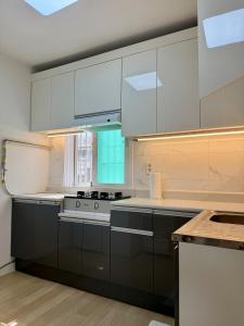 a kitchen with white cabinets and a stove at 1&2 Stay in Daegu