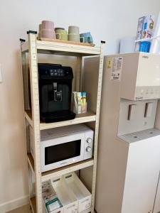 a microwave on a shelf next to a refrigerator at 1&2 Stay in Daegu +12 photos