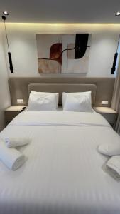 a large white bed with two white towels on it at Triple Tower 23eme étage La vue 329 gare tgv & plage 3min in Tangier