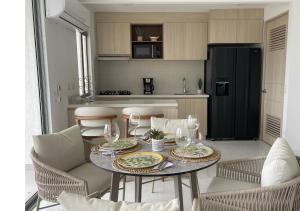 eine Küche mit einem Tisch mit Tellern und Weingläsern in der Unterkunft Apartamento nuevo en Cartagena, Serena del Mar - INAWA in Cartagena de Indias