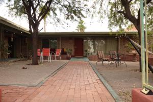 a brick house with a patio with chairs and a table at Dodge Residence in Tucson +3 photos