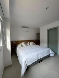 a bedroom with a large white bed with two pillows at Entre Patios in Azul