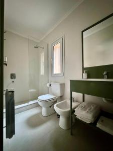 a white bathroom with a toilet and a sink at Entre Patios in Azul