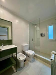 a bathroom with a toilet and a sink and a shower at Entre Patios in Azul
