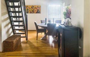a dining room with a table and chairs and a staircase at Nice Apartment In Rysstad With Wifi in Rysstad