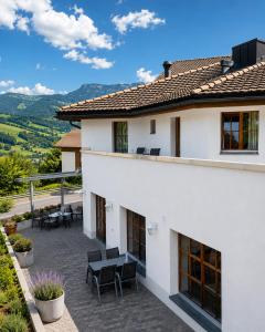ein weißes Haus mit einer Terrasse mit Tischen und Stühlen in der Unterkunft Alpine Hotel Reich in Cazis