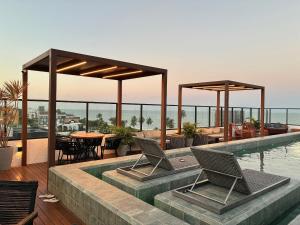 a patio with chairs and a swimming pool at Get By Side na Beira mar do Caribessa Jardim Oceania in João Pessoa