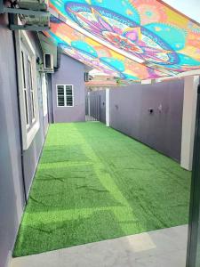 a room with green grass and a colorful ceiling at Lavender Splash Homestay in Ipoh