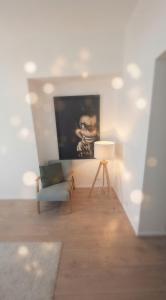 a living room with a chair and a painting on the wall at Élégant stays in Vilvoorde