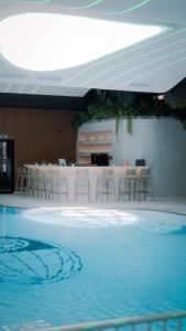 a swimming pool with chairs and a bar in a building at Motel Predejane in Predejane