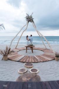 Ein Brautpaar sitzt an einem Tisch am Strand in der Unterkunft Aldea Mizúl - Beach Front - Adults Only in Puerto Escondido