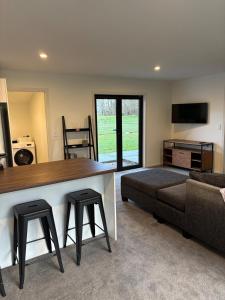 a living room with a couch and a table with stools at Cottage Lifestyle in Fernside
