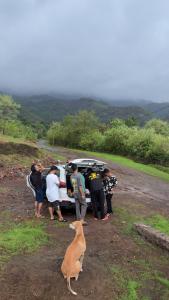 a group of people and a dog standing next to a car at Prince Villa in Neral