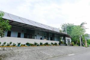 a building with a parking lot in front of it at RedDoorz @ Bukit Dieng 2 in Malang