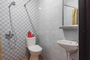 a bathroom with a white toilet and a sink at RedDoorz @ Bukit Dieng 2 in Malang