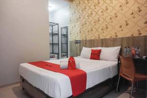 a bedroom with a large bed with red pillows on it at RedDoorz @ Bukit Dieng 2 in Malang +5 photos