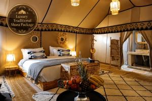 a bedroom with a bed and a table with fruit on it at Luxury Traditional Sahara Package in Merzouga