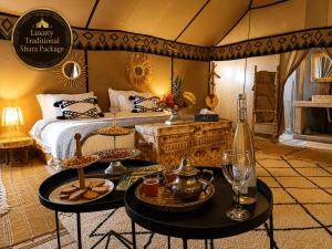a room with a bed and two tables with food at Luxury Traditional Sahara Package in Merzouga