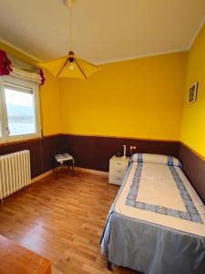 ein Schlafzimmer mit einem Bett und einer gelben Wand in der Unterkunft L'Eixida in Tremp