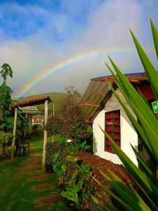 a rainbow in the sky over a house at Bahareque hospedaje in Monguí