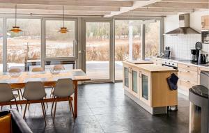 a kitchen with a table and chairs and a kitchen with windows at Nice Home In Röbel With Sauna in Röbel