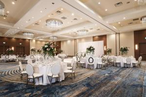 a banquet hall with white tables and chairs and a screen at Vancouver Marriott Pinnacle Downtown Hotel in Vancouver +149 photos