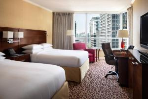 a hotel room with two beds and a desk at Vancouver Marriott Pinnacle Downtown Hotel in Vancouver