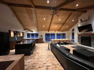 a large living room with a couch and a fireplace at Le Quai 163 in La Macaza
