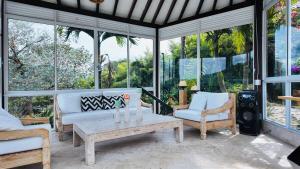 a living room with couches and a table and windows at Finca Villa Rosita 26 in Copacabana