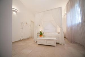 a room with a white bed with a plant on it at Antica Masseria Ficazzana - Tenuta in Marina di Pescoluse