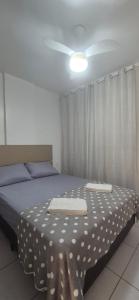a bedroom with a bed with a white polka dot sheet at Praia do Forte - AP DA PAZ in Cabo Frio