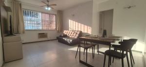 a living room with a table and chairs and a couch at Praia do Forte - AP DA PAZ in Cabo Frio