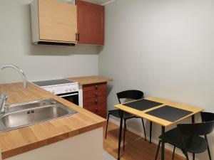 a kitchen with a sink and a table with chairs at Siva's Apartment in Svolvær