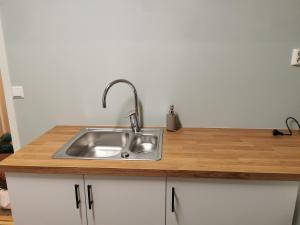 a kitchen sink with a wooden counter top at Siva's Apartment in Svolvær +10 photos