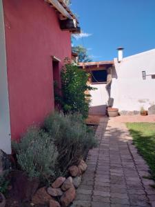 a red and white house with a stone walkway at Ashpa apart in Cafayate