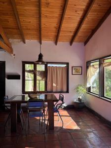 a dining room with a table and chairs and windows at Ashpa apart in Cafayate +17 photos