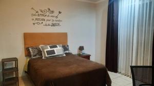 a bedroom with a bed and a sign on the wall at Hospedaje Kelita in Moquegua