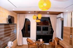 a living room with a table and chairs and a tv at Thong dong homestay&villas in Quỳnh Lưu