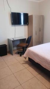 a bedroom with a desk and a bed and a chair at Hospedaje Kelita in Moquegua +9 photos