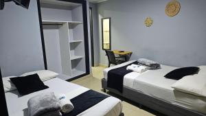 a bedroom with two beds and a mirror at aparta hotel continental estadio in Medellín
