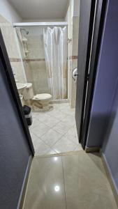 a bathroom with a toilet and a shower at aparta hotel continental estadio in Medellín