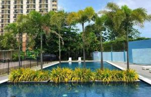a swimming pool with palm trees in a city at Studio Type Furnished Condo in Lapu Lapu City