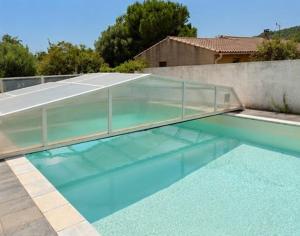 a swimming pool with a glass cover on top of it at Cité château de Carcassonne in Berriac