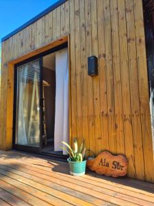 a wooden building with a sliding glass door on a deck at Bio Espacio in Belén de Escobar +6 photos