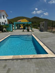 a blue swimming pool in front of a house at Serene Shores, Punta Azul, Westpunt in Westpunt